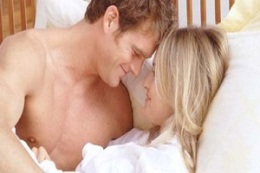 Flirtatious Couple in Bed --- Image by © Larry Williams/CORBIS